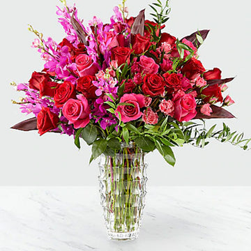 Hot Pink and Red Assortment of Flowers in a Vase with Greens